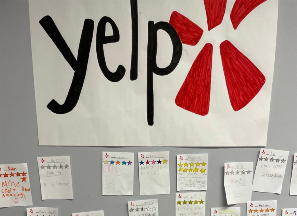 A poster with the Yelp logo surrounded by papers from students