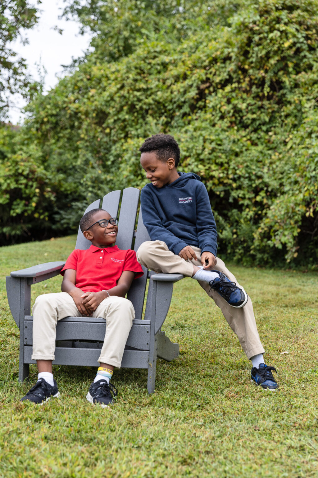 Two boys on chair on front lawn