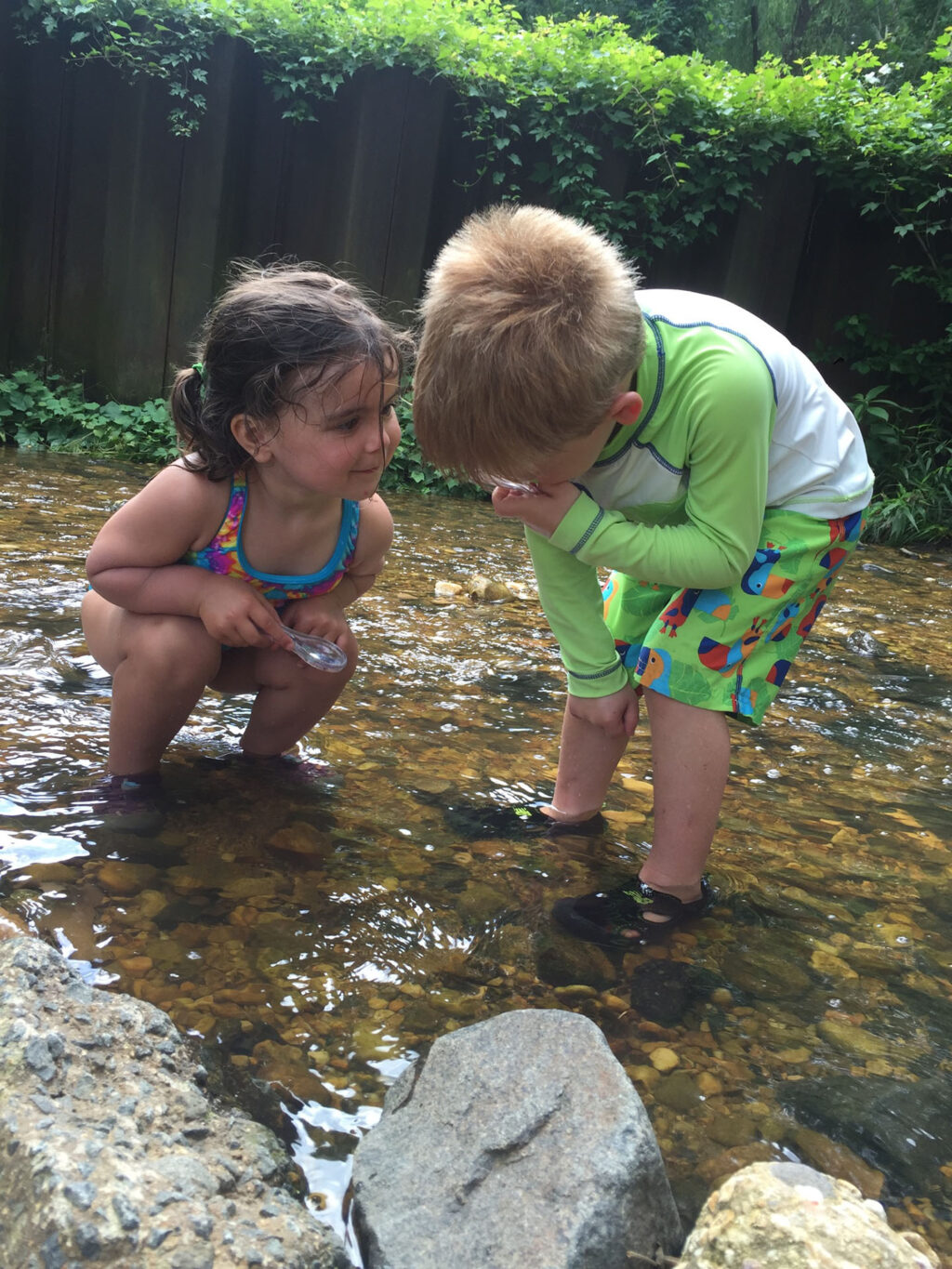 2 kids standing in creek