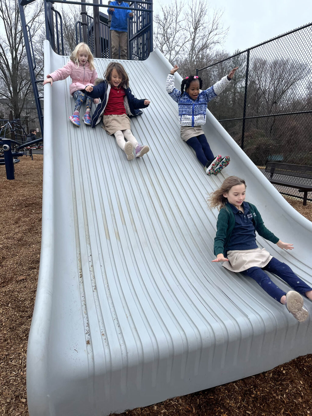 several girls sliding down the new giant slide
